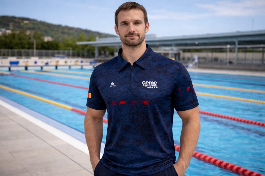 CEME Club Esportiu Hombre de pie junto a una piscina, vestido con una camiseta azul de atleta.